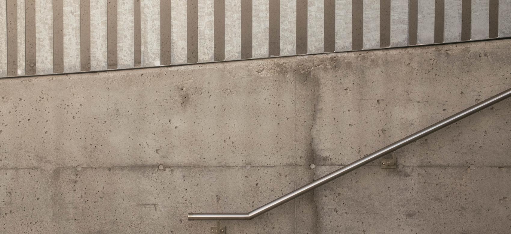 Main courante d'inox brossé et garde-corps galvanisé sur un mur de béton